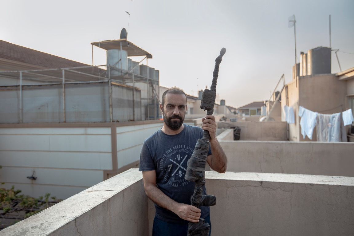 Kurdský umělec Hemn Hamed na balkóně svého ateliéru s jedním z artefaktů.