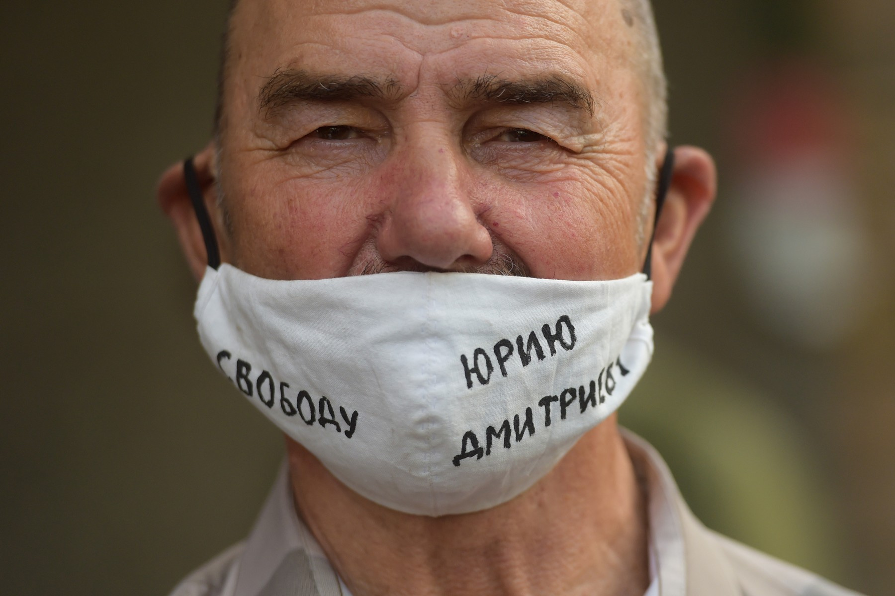 Příznivce ruského historika Jurije Dmitrijeva. Na roušce je nápis požadující jeho propuštění z vězení.