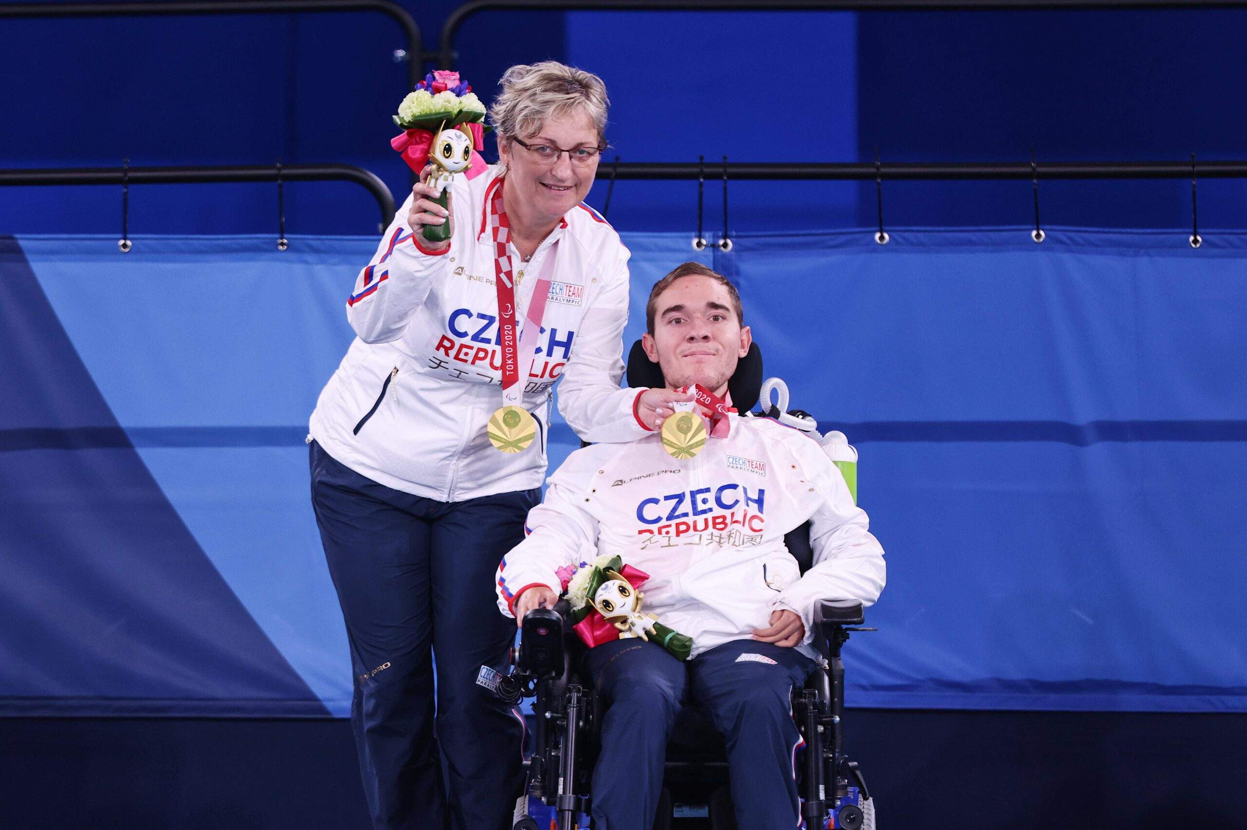 Adam Peška letos na hrách v Tokiu vybojoval zlatou medaili ve sportu boccia. Jeho asistentkou, která se o něj stará při sportu i během dne, je jeho maminka Ivana Pešková.